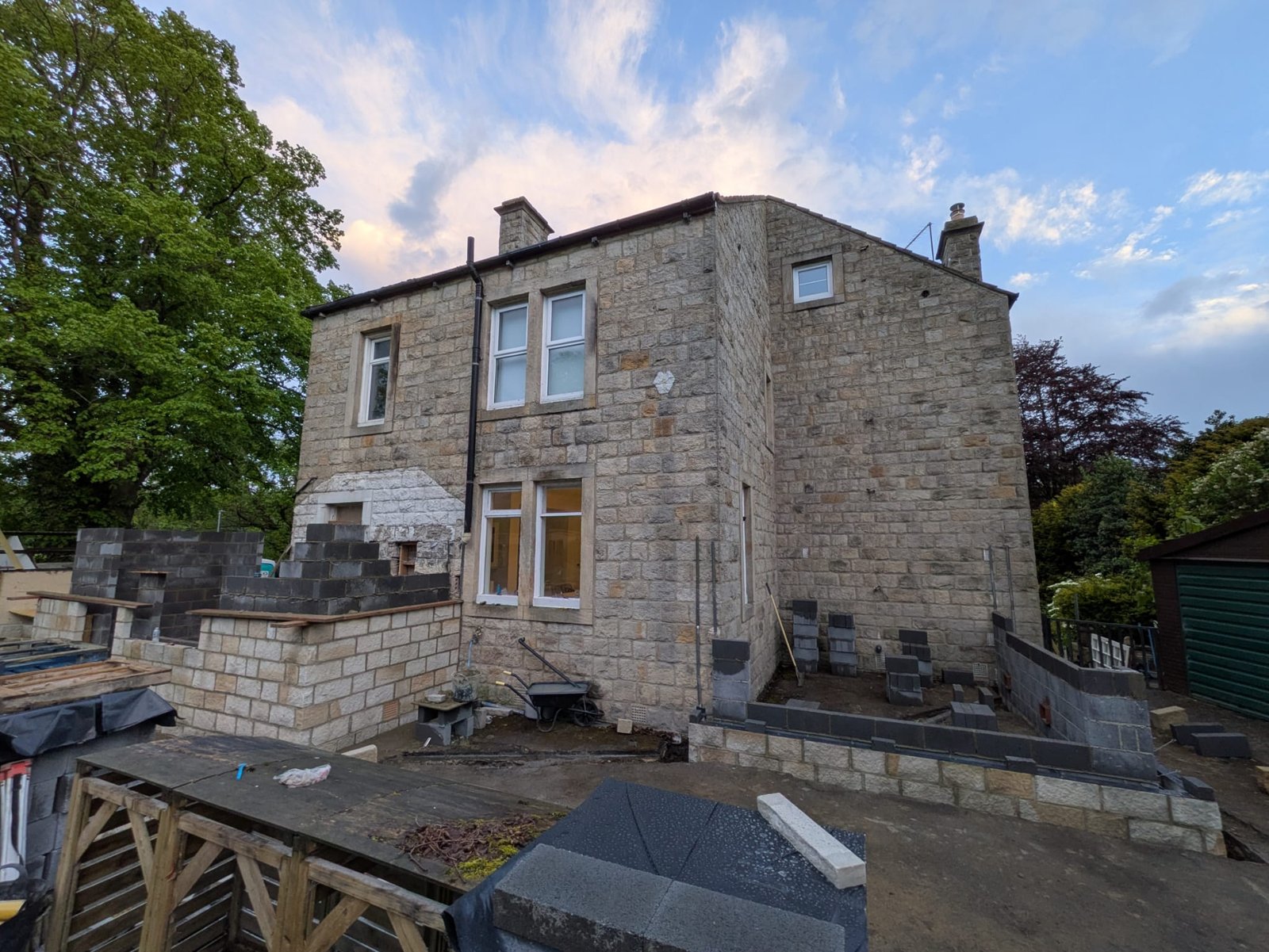 The same extension under construction, with blockwork walls and building materials on site
