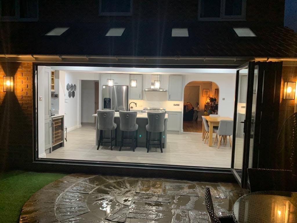 Exterior view of a kitchen and dining extension at dusk with feature wall lighting, Wakefield.