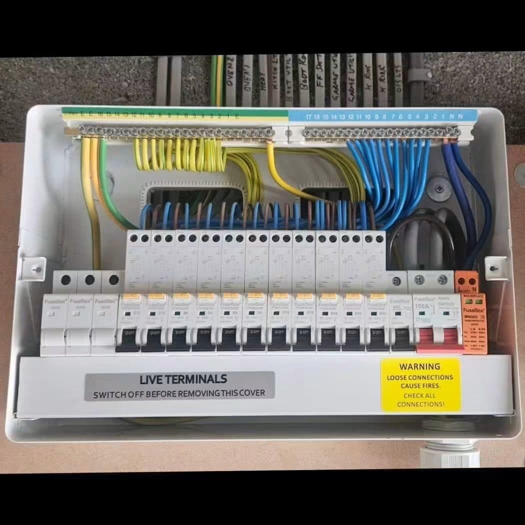 Open consumer unit installation showing neatly dressed cabling, a row of RCBOs, surge protection device and main switch, Leeds