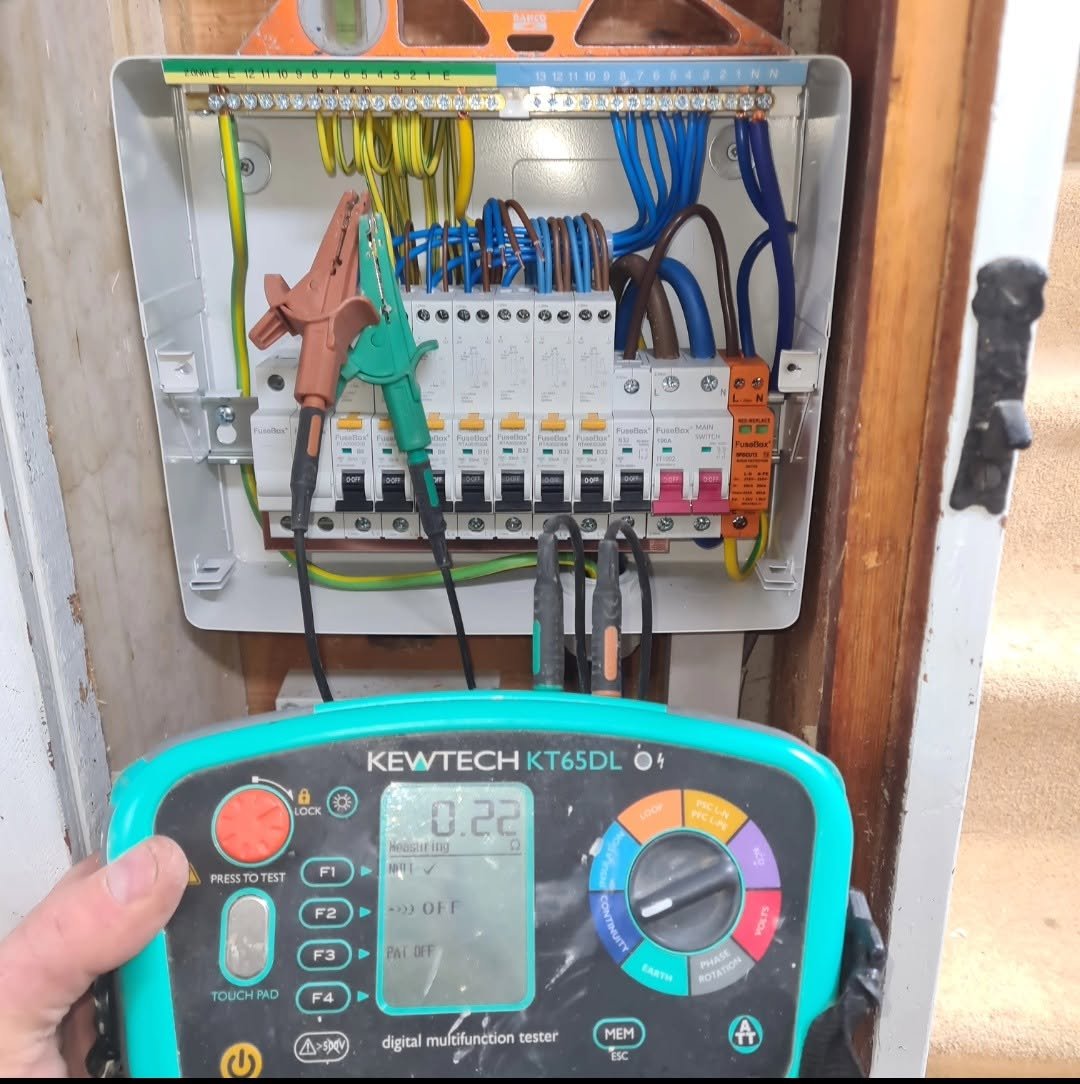 Kewtech KT65DL multifunction tester connected to an open consumer unit during electrical testing, Leeds