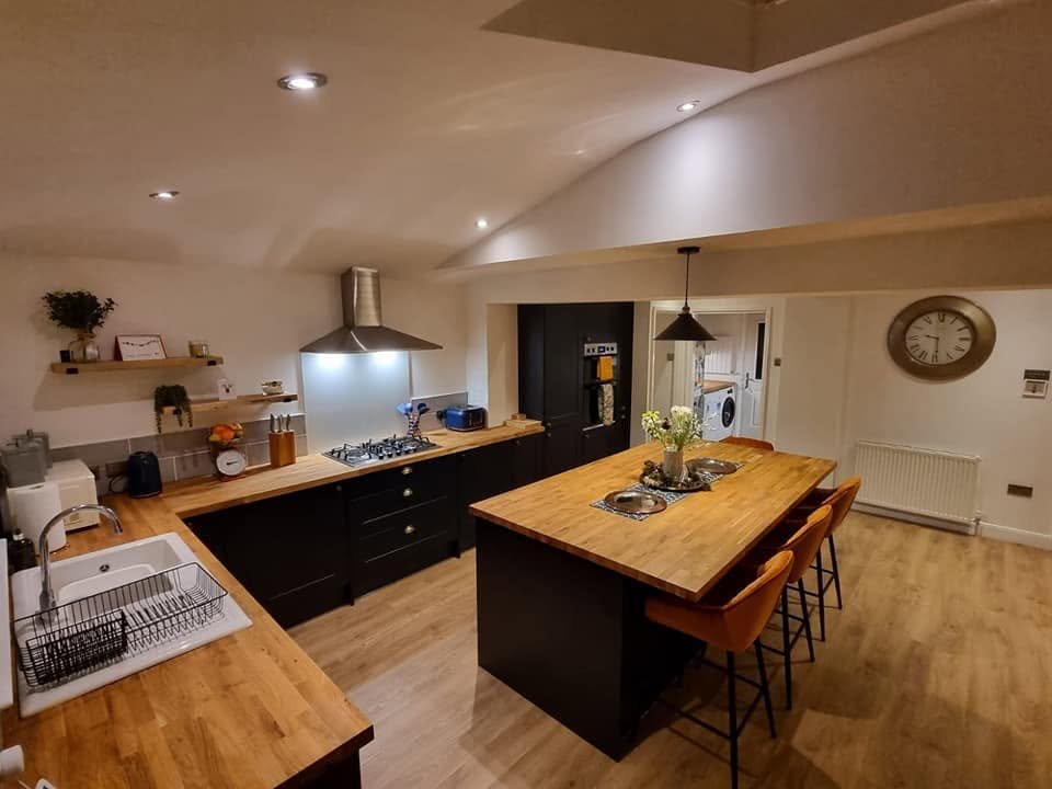 Warm traditional kitchen with island, bar stools and adjoining dining and utility area, Leeds