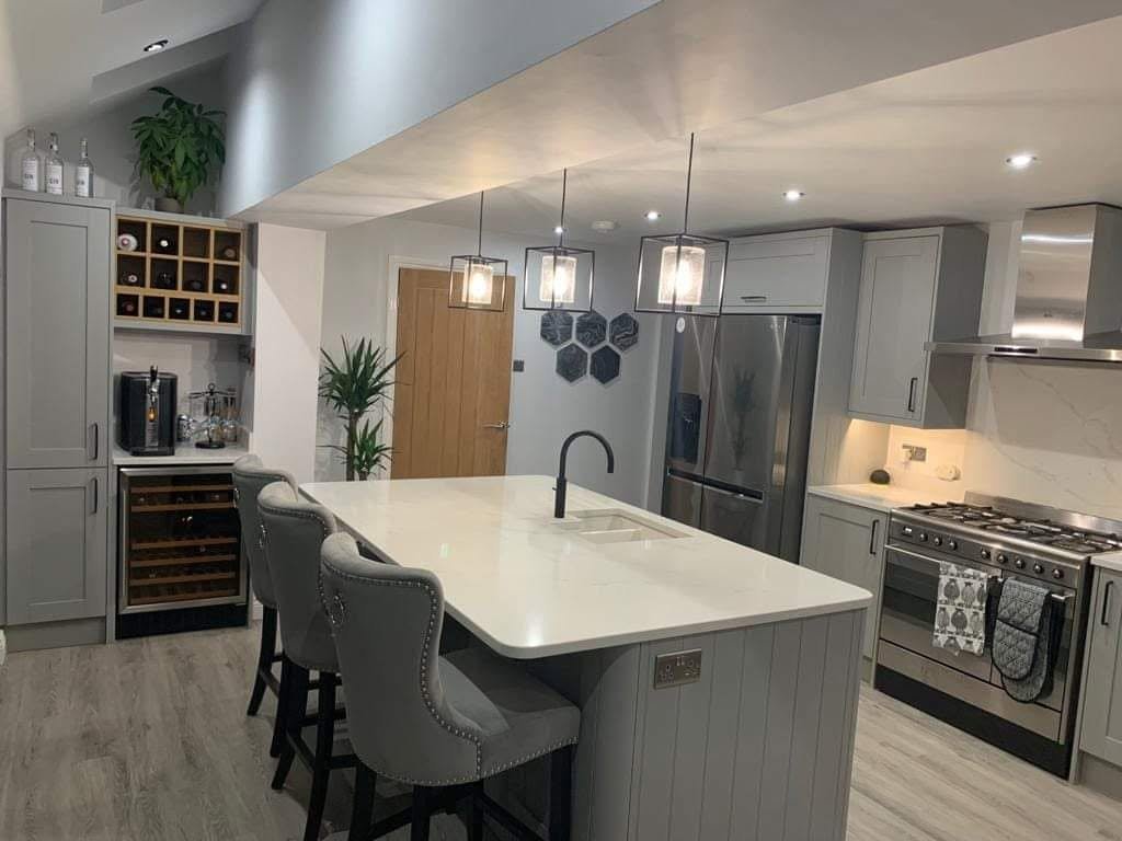 Kitchen island with an electrical socket fitted into the end panel, pendant lighting above, Leeds