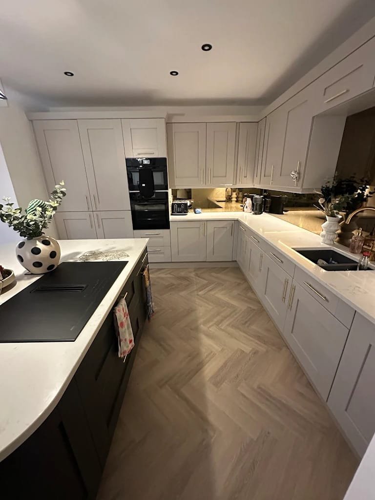 Pale shaker kitchen cabinetry with brass hardware and a mirrored splashback, Leeds