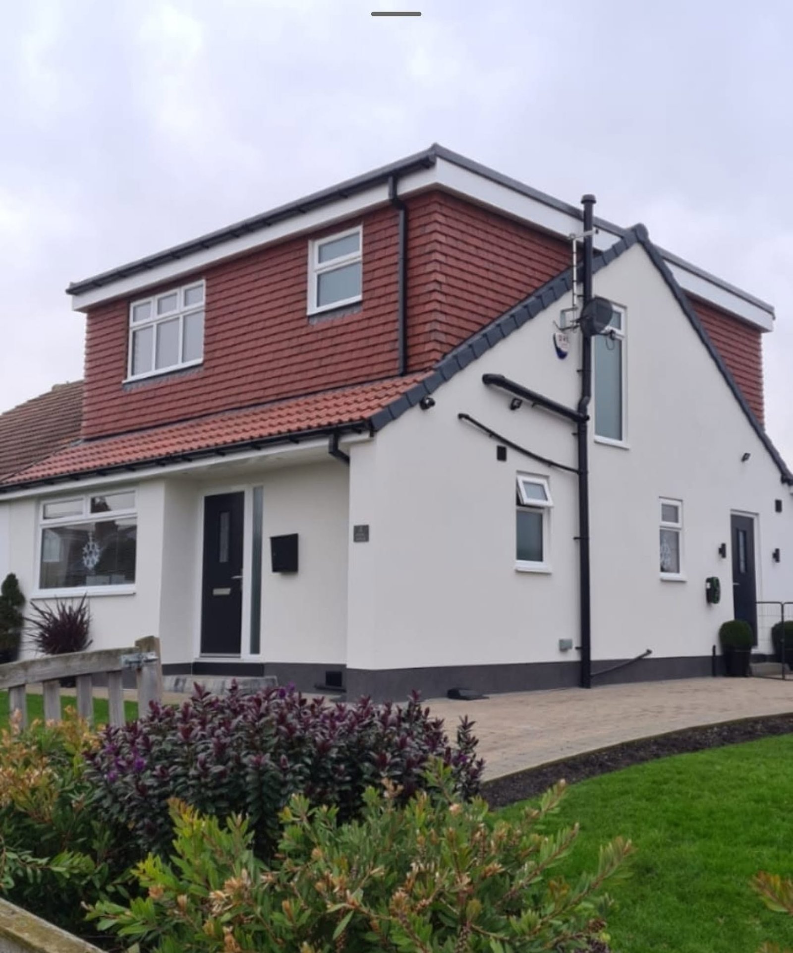 Completed loft conversion with a red-tiled dormer on a detached home, Leeds