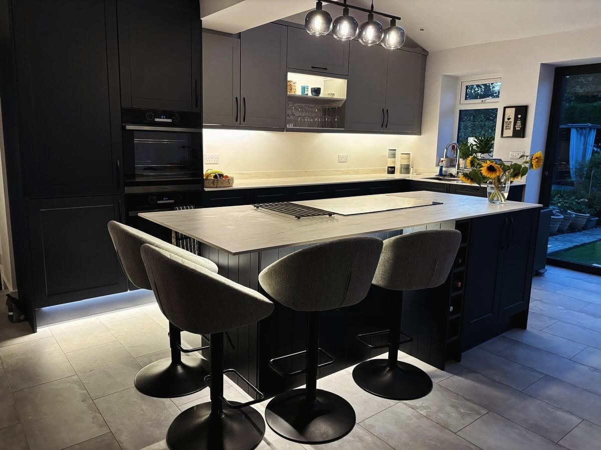 Dark finished kitchen with illuminated under-cabinet lighting, island and pendant fitting, Leeds